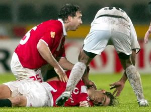 **ATTENTION EDITORS - REPEATING WITH ADDITIONAL INFORMATION** Players help Benfica's Hungarian soccer striker Miklos Feher (down) during the Portuguese Premier League match held at Guimaraes stadium January 25, 2004. Benfica's Hungarian striker Miklos Feher died on Sunday after collapsing during a league game with Vitoria Guimaraes, state TV RTP and SIC television reported. Feher, 24, fell to the ground at Guimaraes' stadium during injury time with Benfica leading 1-0. (PORTUGAL OUT - NO ARCHIVES ) REUTERS/ASF-Paulo Esteves REUTERS